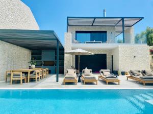 a villa with a swimming pool and a house at Luxury Stone Houses Corfu in Píthos
