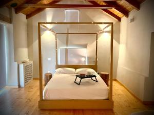 een slaapkamer met een hemelbed en een tafel. bij Sous Un Ciel Différent Struttura con sauna privata in Cortemilia