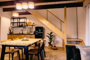 uma cozinha e sala de jantar com mesa e cadeiras em ZaBieszczaduj - apartamenty do wynajęcia em Lutowiska