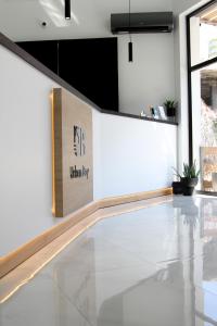 a lobby with a white floor and a sign on a wall at UrbanBay Hotel & Spa in Kavala