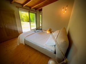 een slaapkamer met een bed met een lamp en een raam bij Sous Un Ciel Différent Struttura con sauna privata in Cortemilia +43 foto's