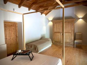 een slaapkamer met een bed en een tafel in een kamer bij Sous Un Ciel Différent Struttura con sauna privata in Cortemilia