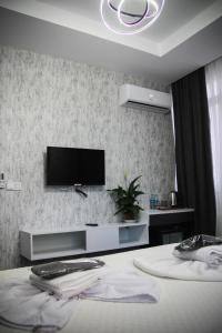 um quarto com uma televisão numa parede com uma cama em The Hera Bostancı em Istambul