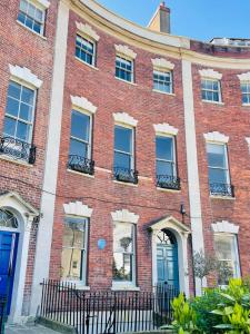 un edificio de ladrillo rojo con ventanas y una puerta azul en Unique Clifton apartment on historic crescent, en Bristol