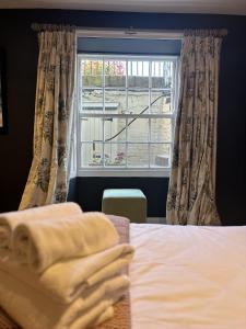a bedroom with a bed with a window and a towel at Unique Clifton apartment on historic crescent in Bristol