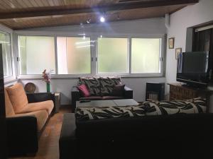 uma sala de estar com dois sofás e uma televisão em CASA NECHO 