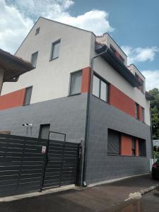 un bâtiment avec une clôture devant lui dans l'établissement Sabina Apartaments, à Sfântu-Gheorghe