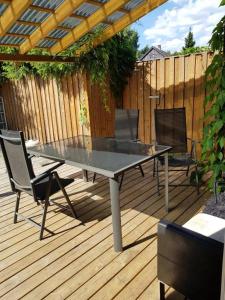 a table and chairs on a deck with a fence at Aparthouse OSLO in Oslo