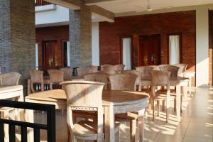 a row of wooden tables and chairs in a room at Gelatik Bed And Breakfast in Seminyak +62 photos