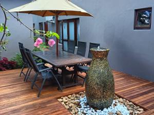 een patio met een tafel en een vaas in het midden bij 37 On Anderson in Pretoria