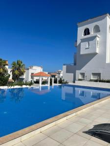 a large swimming pool in front of a building at Les jardins d’Assilah in Asilah