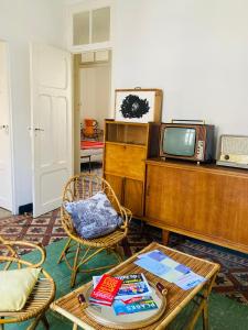 a living room with a table and a tv at Les Cagettes en Ville in Perpignan