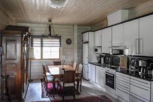 uma cozinha com uma mesa e uma sala de jantar em Villa Classic em Ahtari