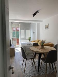 uma sala de estar com uma cama, uma mesa e cadeiras em La Lúnula by Twelve Apartments VUT3392AS em Gijón