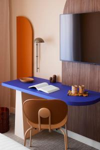 Habitación con escritorio azul y silla. en Hotel Abrial en Cannes