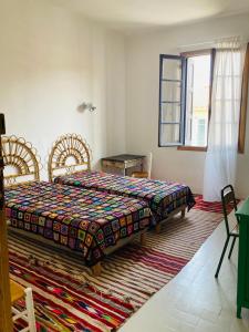a bedroom with a bed and two chairs and a window at Les Cagettes en Ville in Perpignan