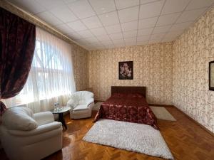 1 dormitorio con 1 cama, 2 sillas y ventana en Barvy Dnipra, en Dnipro