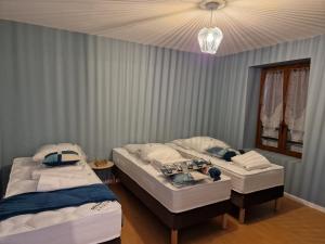 2 łóżka pojedyncze w sypialni z żyrandolem w obiekcie Gîtes du Château de Crespy 