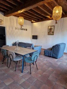 a room with a table and chairs and a couch at Gîtes du Château de Crespy 