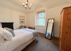 a bedroom with a bed and a mirror in it at Carlibar Villa in Barrhead