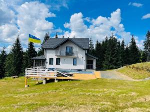 a house on a hill with a flag on it at Lidia chalets in Polyanitsa Popovichevskaya