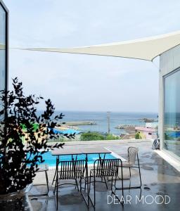 a table and chairs on a patio with a view of the ocean at Pohang Poolvilla Dearmood in Pohang