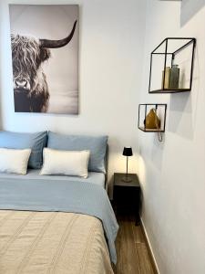 a bedroom with a bed and a picture of a bull at Casa Pirilampo Ferragudo in Ferragudo