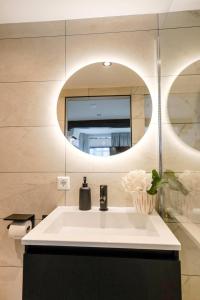 een badkamer met een wastafel en een spiegel bij Deluxe 20m2 Canal View in Delft