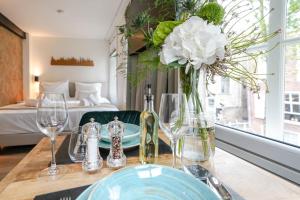 a table with a vase of flowers and wine glasses at Deluxe 20m2 Canal View in Delft