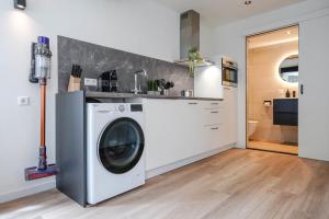 a laundry room with a washing machine in a kitchen at Deluxe 20m2 Canal View in Delft