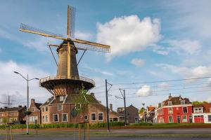 een windmolen bovenop een gebouw in een stad bij Deluxe 20m2 Canal View in Delft