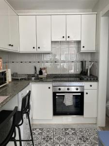 uma cozinha com armários brancos e um forno em La Lúnula by Twelve Apartments VUT3392AS em Gijón