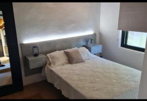 a bedroom with a white bed with two night stands at Casita Sarabia in Ponteareas +19 photos