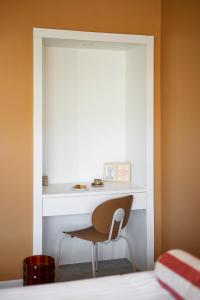 a room with a desk and a chair next to a bed at Hotel Abrial in Cannes