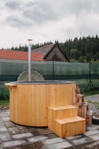 una bañera de hidromasaje de madera con un banco en un patio en Casa Florea Stanceni en Ciobotani
