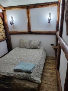 1 dormitorio pequeño con 1 cama en una casa en Cabana MARISA en Dărmăneşti