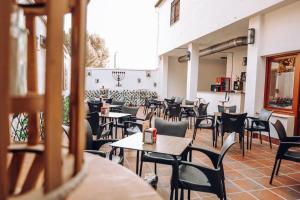 un restaurant vide avec des tables et des chaises dans l'établissement Hospedium Hostal Ben Nassar, à Arjona