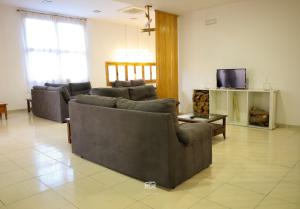 a living room with two couches and a tv at Hospedium Hostal Ben Nassar in Arjona