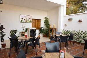 - un restaurant avec des tables et des chaises dans une salle dans l'établissement Hospedium Hostal Ben Nassar, à Arjona