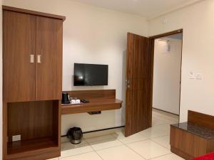 a room with a television and a wooden cabinet at JESTA RESIDENCY in Hassan