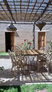 patio ze stołem i krzesłami pod pergolą w obiekcie Ecolodge unique aux portes d'Agafay - La Canisse w mieście Oumnas