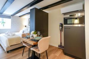 Habitación con cama, mesa y cocina. en Luxury City Center Studio en Delft