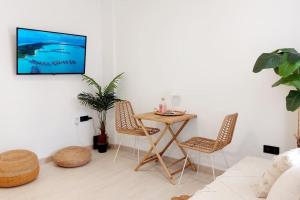 una sala de estar con una mesa y sillas en Boho Studio with Patio in Centre and Close to Beach, en Nerja