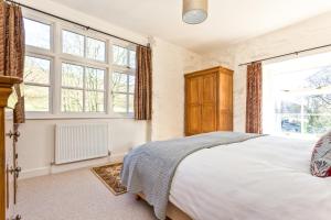 a bedroom with a large bed and large windows at Charcoal House in Coniston