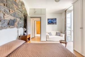una camera con letto e parete in pietra di [Como 100MQ] 5 mins to center + Free Park and View a Como