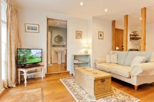 a living room with a couch and a tv at Charcoal House in Coniston