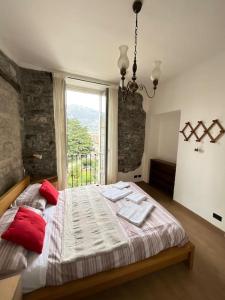 una camera da letto con un letto con cuscini rossi e una finestra di [Como 100MQ] 5 mins to center + Free Park and View a Como