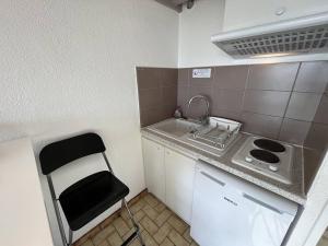 une petite cuisine avec un évier et une cuisinière dans l'établissement Studio à 50m de la plage, à Saint Pierre La Mer