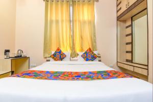 a bedroom with a large white bed with a window at FabHotel The Grand Kailash in Jaipur