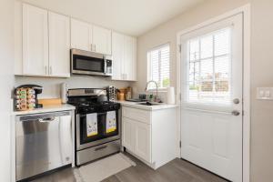 聖地牙哥的住宿－San Diego Haven，厨房配有白色橱柜和炉灶烤箱。